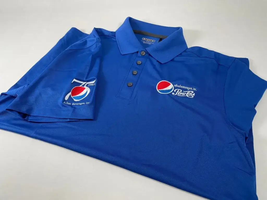 Custom blue polo shirt featuring Pepsi logo and "75 years" embroidery, representing branded apparel for corporate events and team unity.